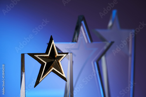 group of star shape crystal trophies against blue and pink background