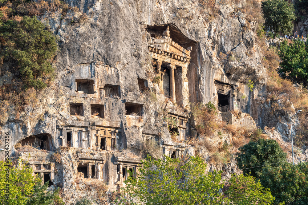 Rock tombs carved into the steep slopes of the southern hills of Fethiye town on the Mediterranean coast of Turkey.