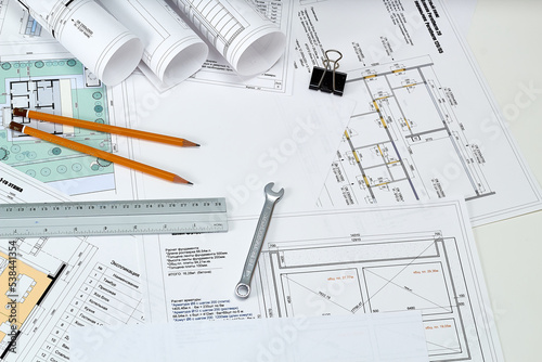 Designer's tools, construction drawings and wrench.