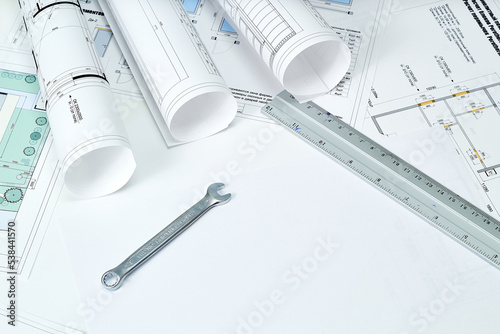 Designer's tools, construction drawings and wrench.