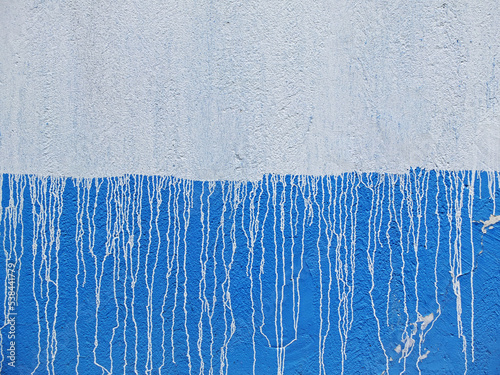 Blue and white concrete wall with white streaks of paint as background or texture