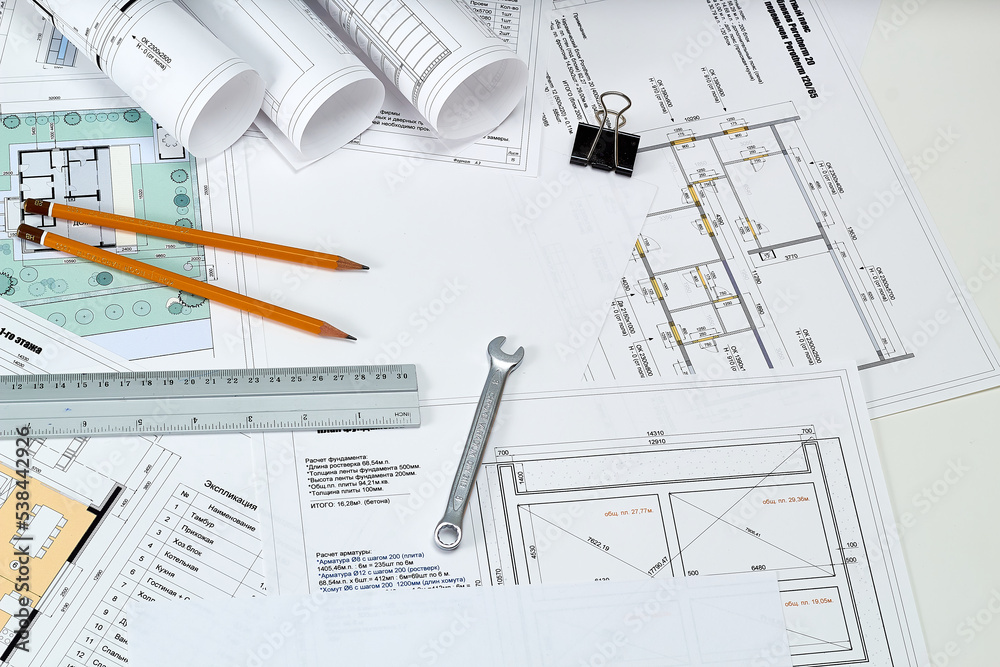 Designer's tools, construction drawings and wrench. Designer's tools, construction drawings and wrench.