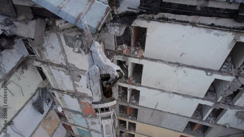 Excavator for dismantling buildings, using a special claw, dismantles a multi-storey building. Ukraine. 4k