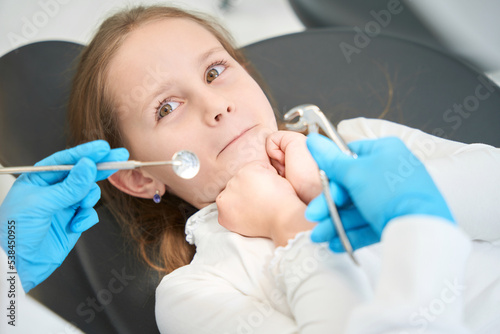 Pre-teen child feeling scared of upcoming tooth extraction