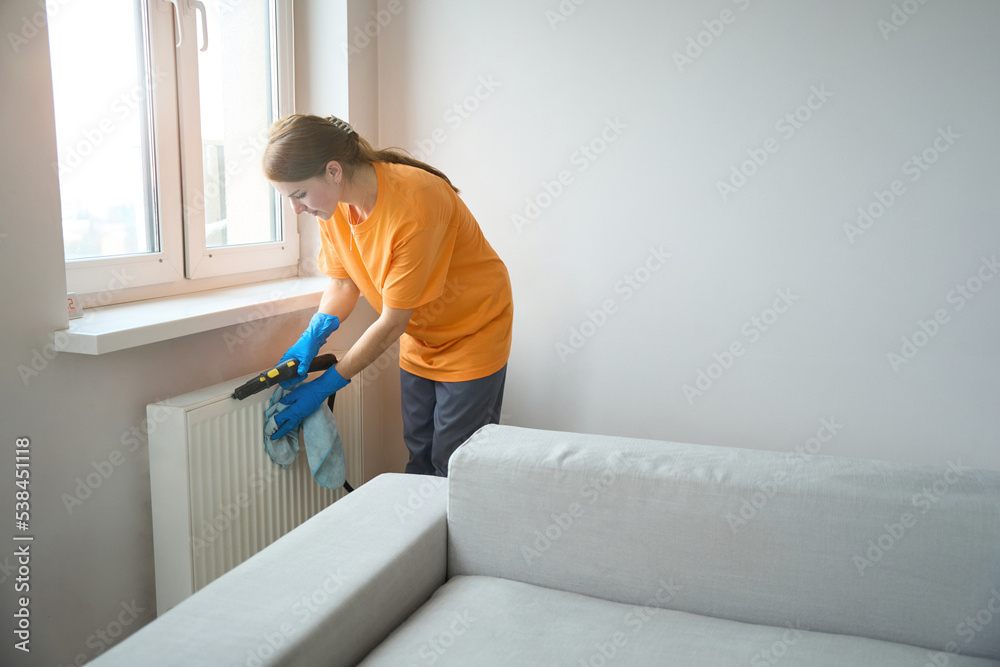 Close up photo of female cleaning heaters