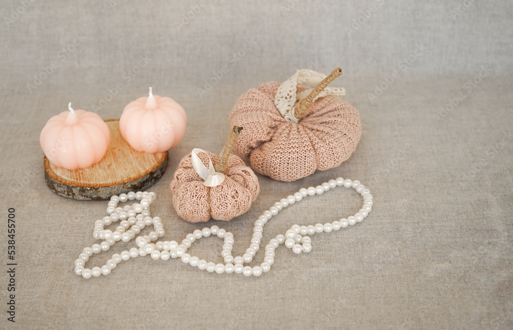 Hobby background with handmade knit pumpkins and white pearl beads. DIY, craft decoration for fall and winter holidays. Hobby background with handmade knit pumpkins and white pearl beads. DIY, craft decoration for fall and winter holidays.