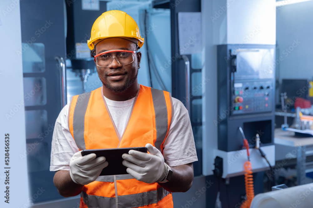 Professional african american engineer worker use tablet computer background CNC machine. Happy Industry portrait of manufacture