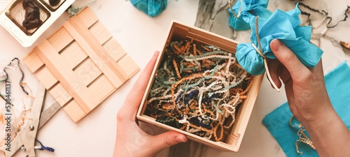 Teenage girl making handmade Christmas gift with chocolate sweets for New Year, Christmas holidays. Do it yourself concept, creativity, step by step process. Banner.