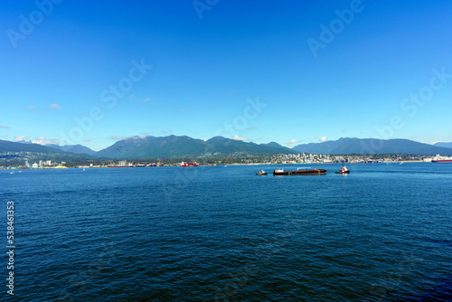 Shipping on Vancouver Harbor, BC, with Lonsdale Quay and North Shore mountains in background, as seen from cruise ship terminal at Canada Place. photo