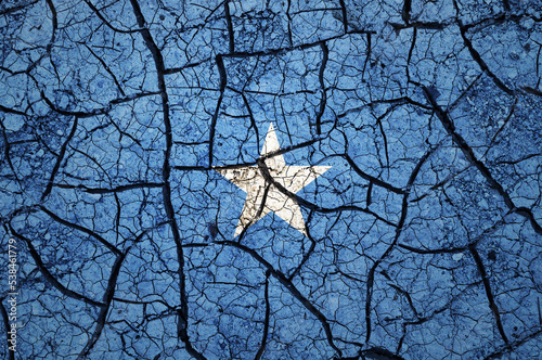 Dry soil pattern on the flag of Somalia. Country with drought concept. Water problem. Dry cracked earth country.	 photo