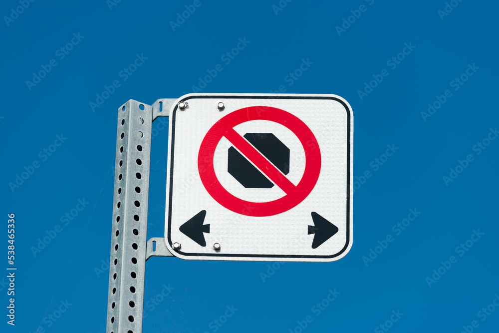 no stopping on either side of the metal post/sign (on a blue sky) no stopping on either side of the metal post/sign (on a blue sky)