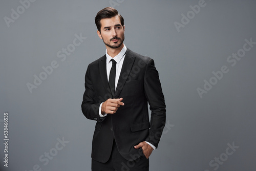 Man confident businessman in a stylish suit with jacket tie and white shirt on a gray background portrait. The concept of young businesses and startups