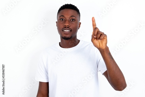 MODEL showing and pointing up with fingers number one while smiling confident and happy.
