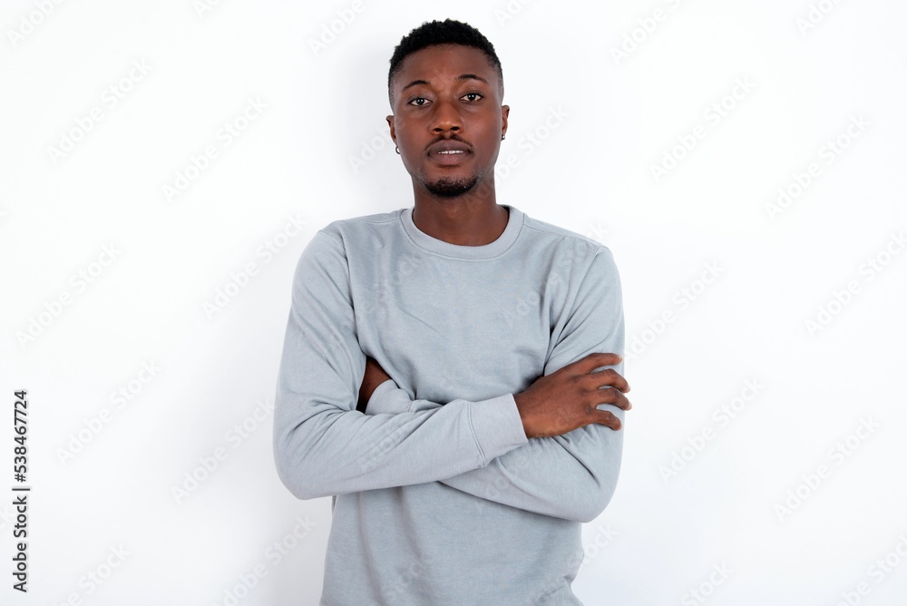 Self confident serious calm young handsome man wearing grey sweater over  white background stands with arms folded. Shows professional vibe stands in  assertive pose. Stock Photo | Adobe Stock