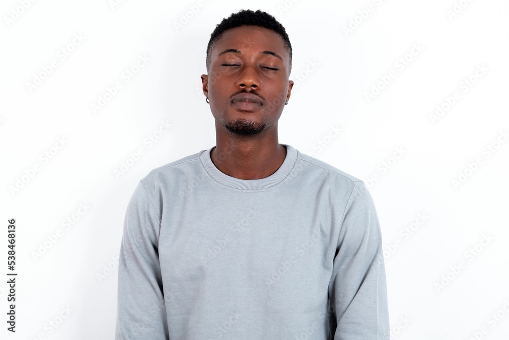 young handsome man wearing grey sweater over white background nice-looking sweet charming cute attractive lovely winsome sweet peaceful closed eyes