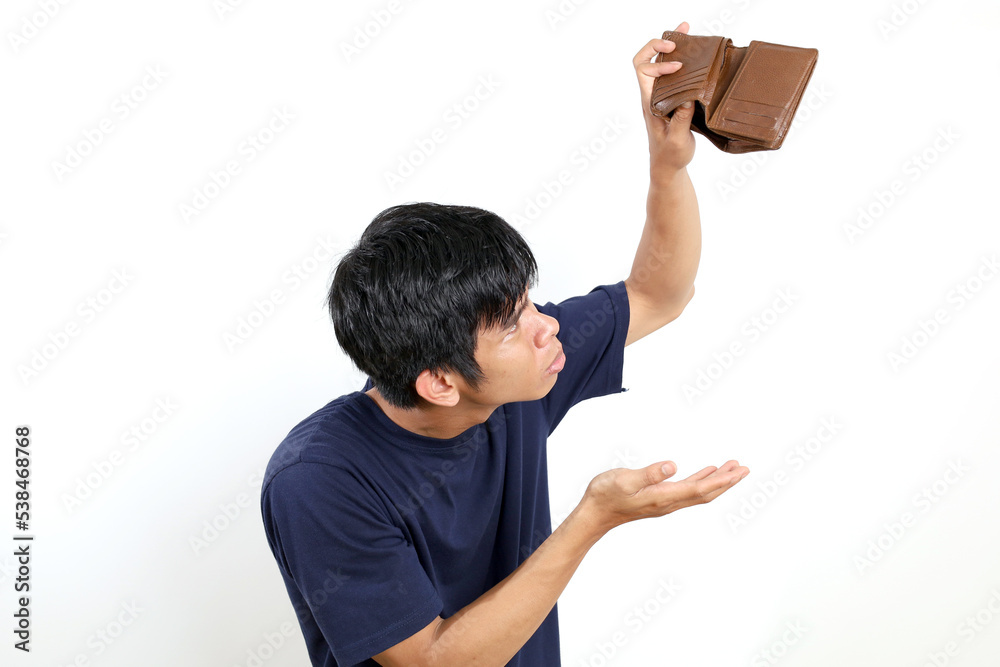 Disappointed young asian man standing while opening his empty wallet. Isolated on white background Disappointed young asian man standing while opening his empty wallet. Isolated on white background
