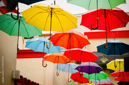 Colorful hanging umbrellas with slightly noticeable water drops
