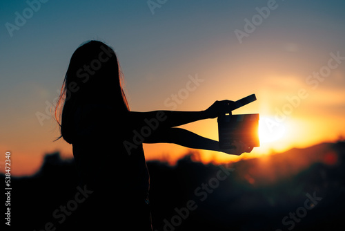 Photos Silhouette of a Woman Holding a Cinema Clapperboard in the Sunset