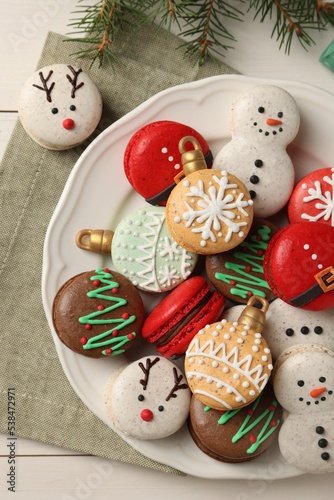 Beautifully decorated Christmas macarons on white wooden table, flat lay