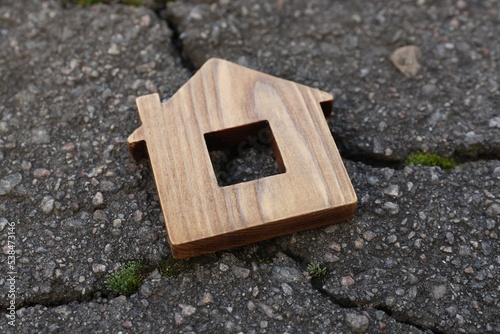Wooden house model on cracked asphalt. Earthquake disaster © New Africa