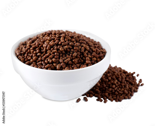 Bowl with buckwheat tea granules on white background