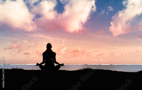 silhouette of woman meditating by the sea. Body health and balance. 