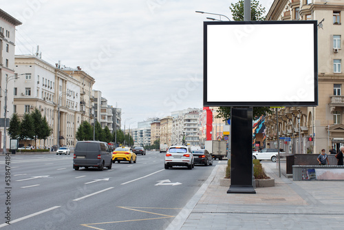 Blank horizontal large billboard in the city. City center, cloudy sky, highway. Mock-up.