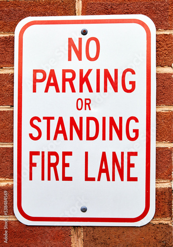 No Parking or Standing in Fire Lane sign on brick wall photo