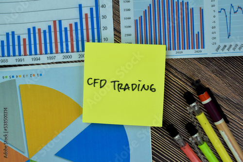 Concept of CFD Trading write on sticky notes isolated on Wooden Table. photo