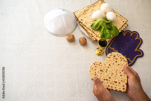 Man's hands holds Matzah shape of heart. Traditional of Jewish Holiday on Passover. Home symbol of lovely family. top view, layout. love and care. Gift for lovers. Feeling in love and blissful life