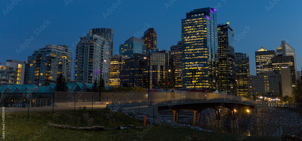 Calgary's cityscape reflected in the river water at dusk.