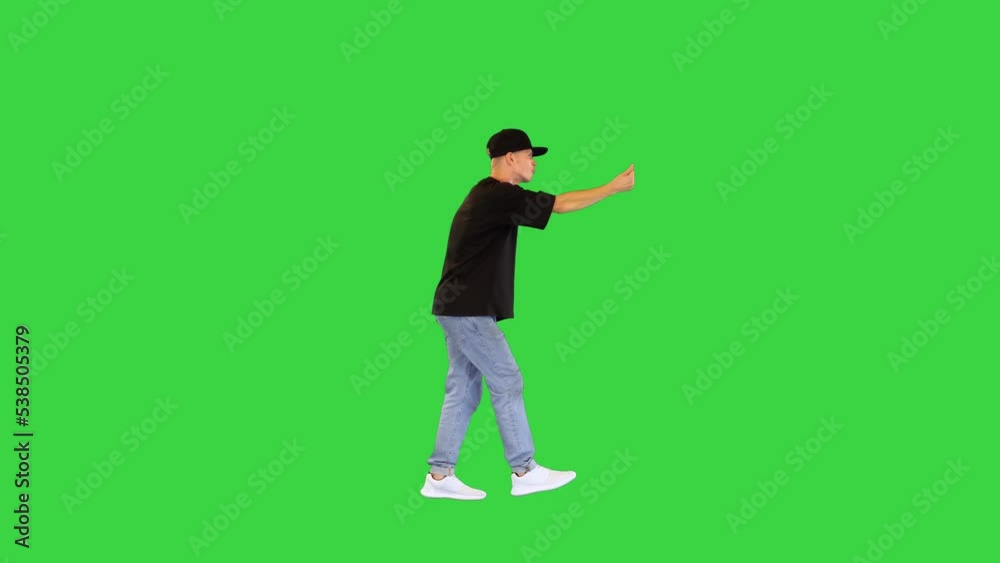 Cool guy in a cap rapping making gestures and walking on a Green Screen, Chroma Key. Cool guy in a cap rapping making gestures and walking on a Green Screen, Chroma Key.