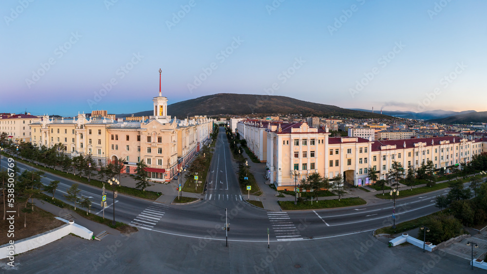 Aerial view of the city of Magadan. Panoramic cityscape. Streets and buildings in the historical center of the city. Beautiful old tower with a spire. Magadan, Magadan region, Far East of Russia.