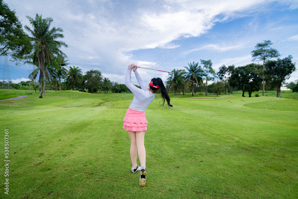 Professional woman golfer teeing golf in golf tournament competition at golf course for winner	