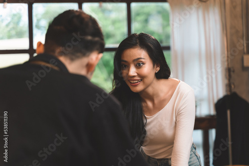 woman customer in restaurant choosing food on menu in tablet and waiter take a note for the order form customer. woman in restaurant with the man owner on waiter uniform and service customer.