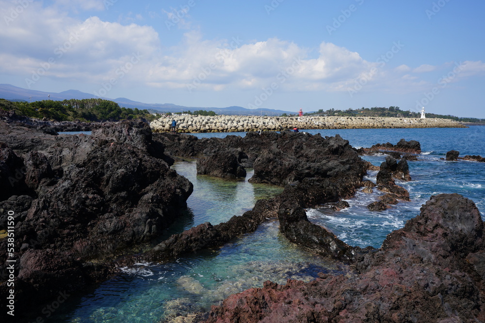 clear rock coast and distant lighthouse