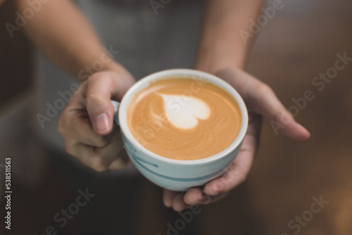 waitress handing and sip a coffee and present coffee with smiling. the happiness woman in coffee shop on waitress uniform and service customer.