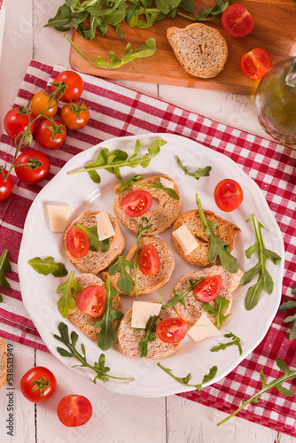 Friselle with cherry tomatoes and arugula.