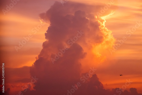Giant clouds against orange sky at sunset