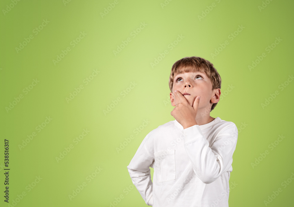 Boy looking up, thoughtful portrait on copy space green backgrou Boy looking up, thoughtful portrait on copy space green backgrou