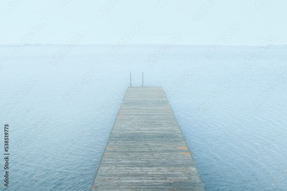 Wooden jetty on lake in fog a calm day in serenity Wooden jetty on lake in fog a calm day in serenity