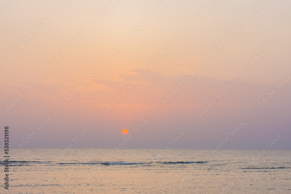 amazing sunrise with orange warm sun and colorful sky at the sea