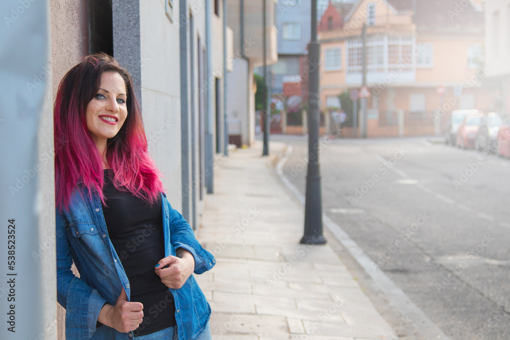 Fototapeta premium urban young woman leaning on the wall in the street
