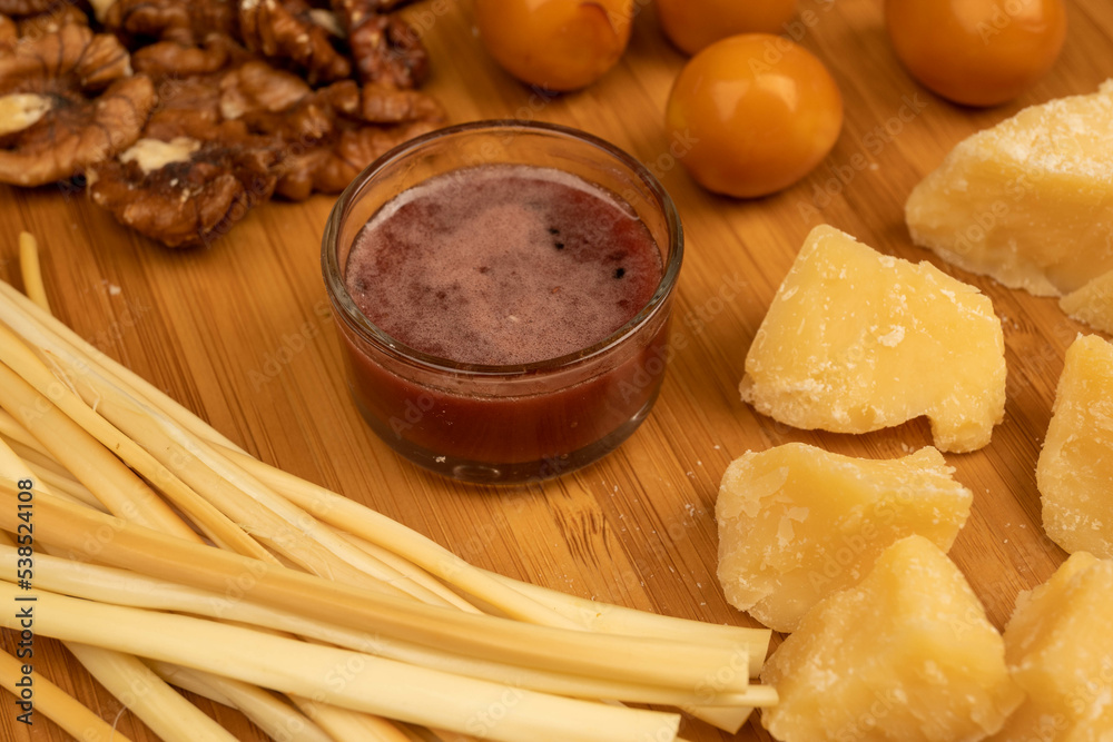 Various varieties of cheese, walnut kernels, smoked quail eggs and honey in a glass vase on a wooden surface Various varieties of cheese, walnut kernels, smoked quail eggs and honey in a glass vase on a wooden surface