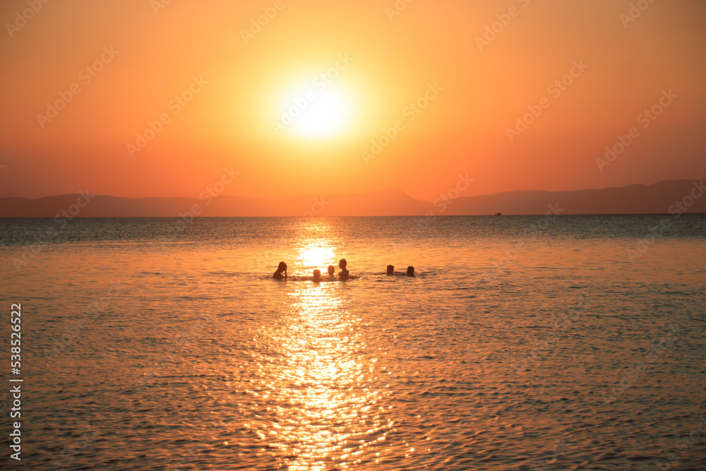 Silhouettes of people enjoying the warm sea during the sunset in Koh Tonsay or Rabbit Island in Cambodia Silhouettes of people enjoying the warm sea during the sunset in Koh Tonsay or Rabbit Island in Cambodia