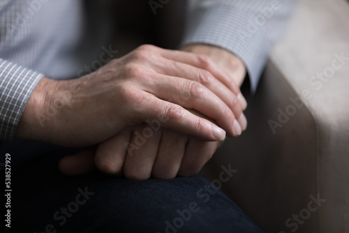 Close up view, cropped shot, palms of unknown senior 65s Caucasian male folded on knees. Posture of thoughtful unrecognizable man, lonely person, senile diseases, medical insurance for older citizen