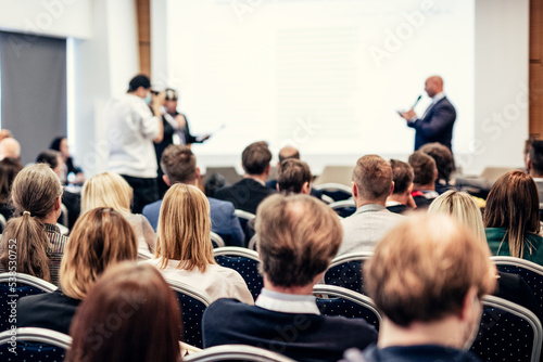I have a question. Group of business people sitting in conference hall. Businessman raising his arm. Conference and Presentation. Business and Entrepreneurship