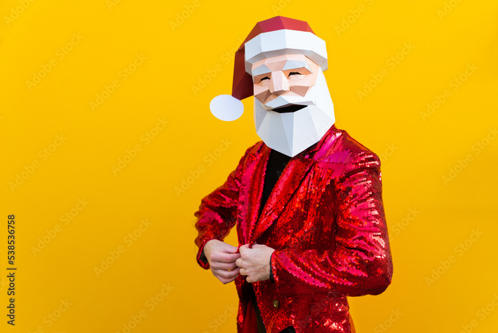 Man with funny Santa Claus low poly origami mask on colored background, colorful costume  for Christmas holiday
