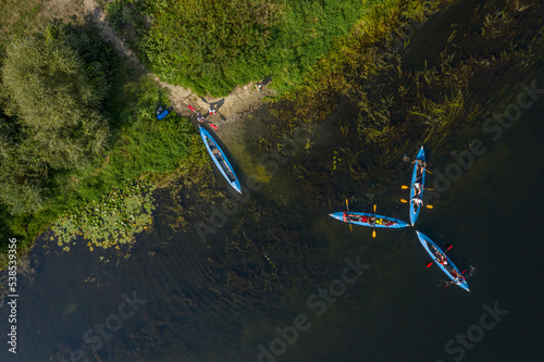 Kayaking and canoeing in the summer river. Aerial drone view on kayaks and river bank. photo