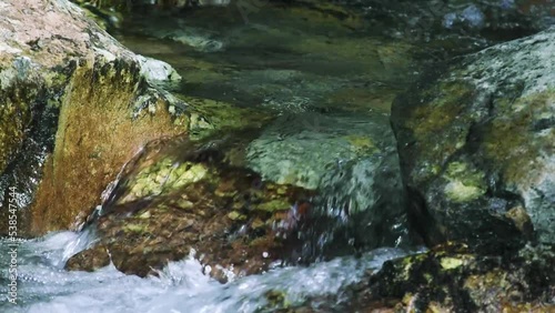 clear river water flowing over the rocks, close-up